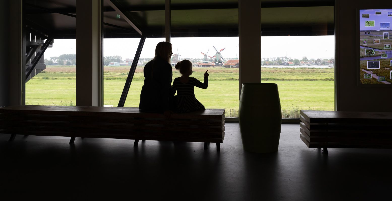 Uitzicht op de molens van de Zaanse Schans vanuit Molenmuseum De Zaansche Molen. Ontdek in dit museum alles over de molens van de Zaanstreek en vier hun honderjarige jubileum mee. Foto: Vereniging De Zaansche Molen