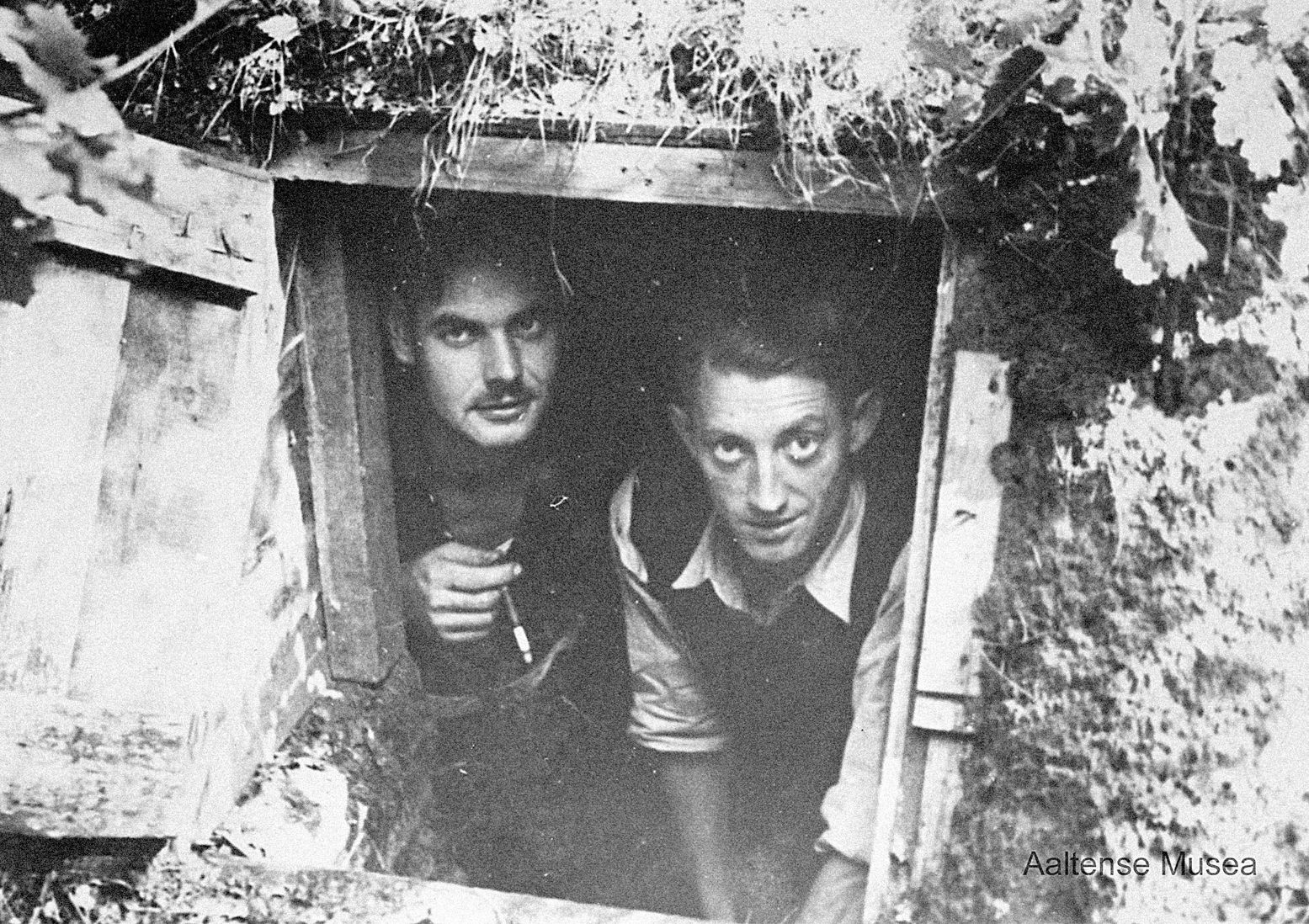 Bernard Jansen en verrzetsman Bernard van Eerden (rechts) poseren voor de ingang van hun schuilplaats bij Aalten. Foto: Nationaal Onderduikmuseum