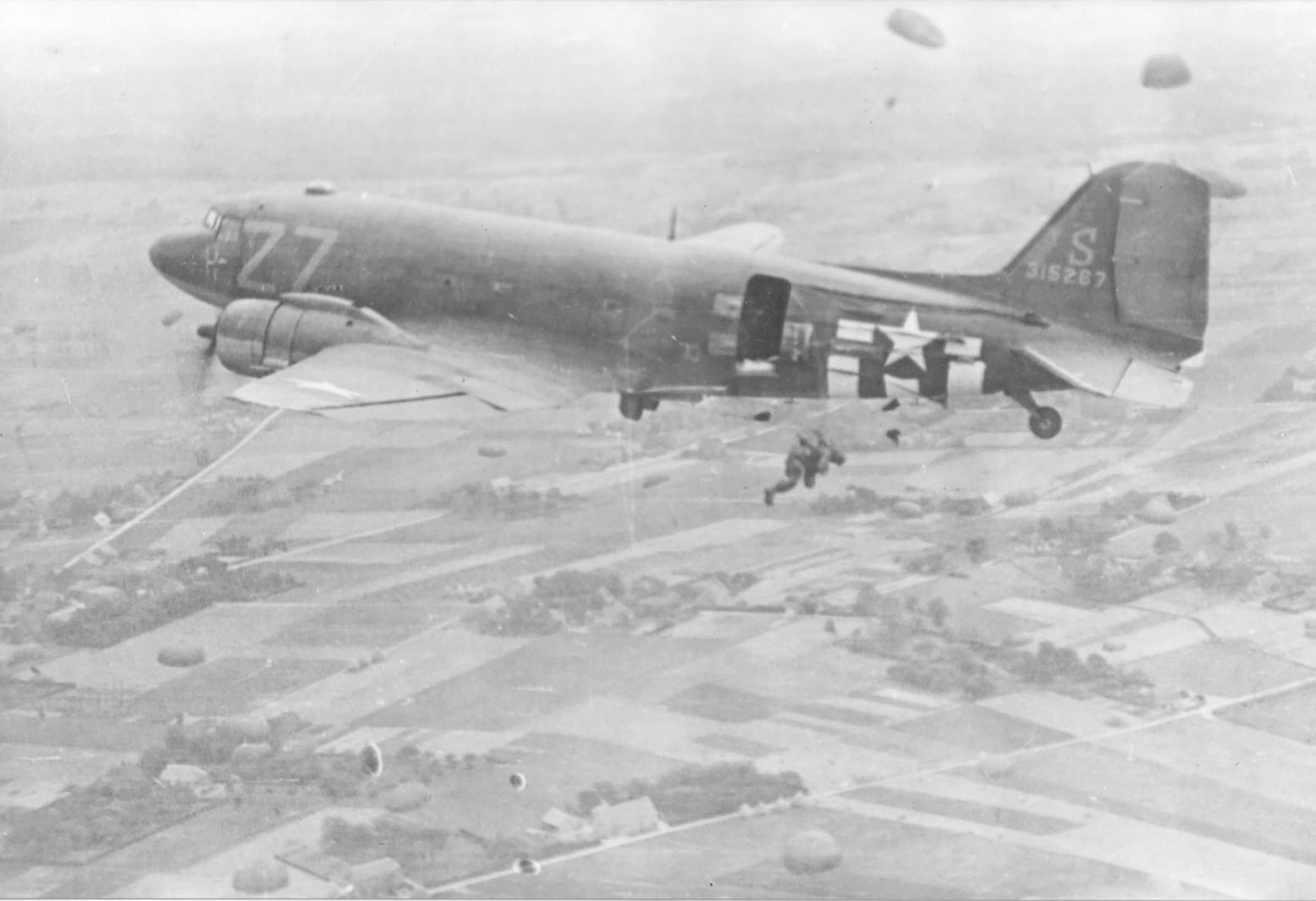 Amerikaanse parachutisten springen in 1944 boven Groesbeek uit het vliegtuig. Foto: Vrijheidsmuseum